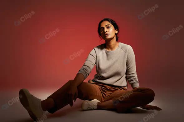 Relaxed Woman in Casual Outfit with Red Studio Background