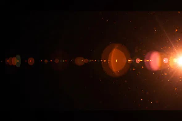 Horizontal Warm Lens Flare Trail with Particles and Bokeh Glow