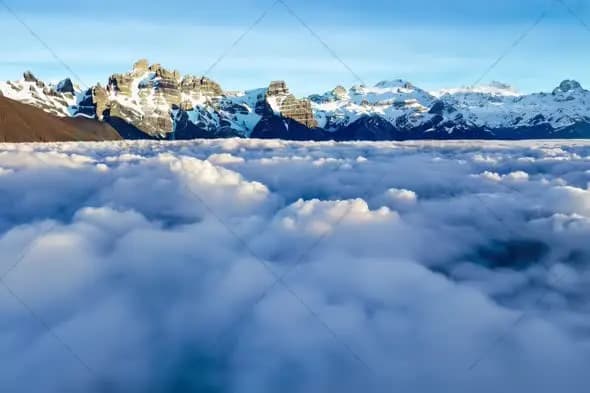 Majestic Snow Capped Mountains Above Cloud Sea at Sunrise