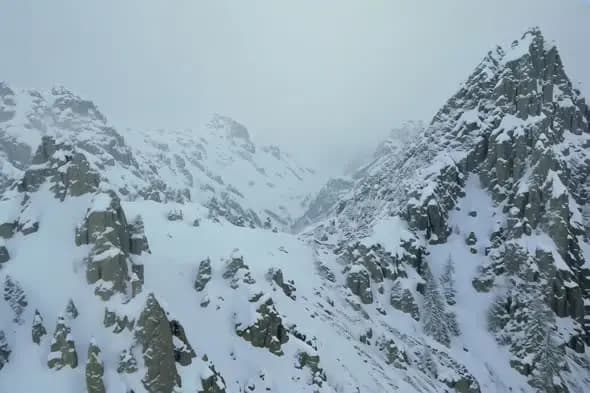 Majestic Snow-Covered Mountain Range in Misty Winter Conditions