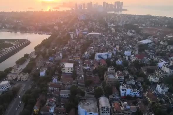 Aerial Sunset View of Urban Coastal City with Modern Skyline