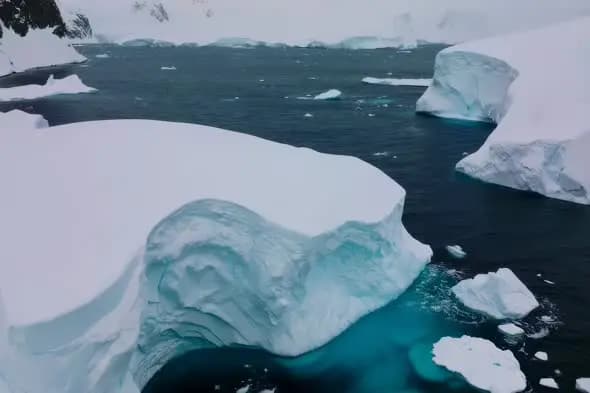 Massive Icebergs Floating in Turquoise Antarctic Waters