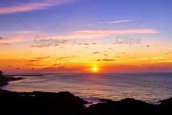 Dramatic Coastal Sunset Over Rocky Shoreline