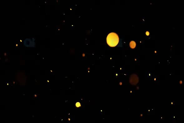 Golden Sparkling Particles Floating on Black Background
