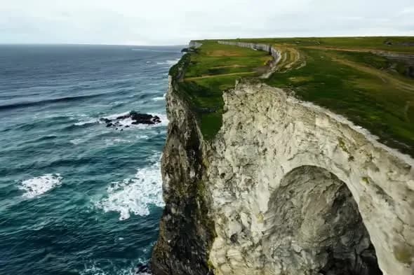 Dramatic Coastal Chalk Cliffs with Crashing Waves Aerial View