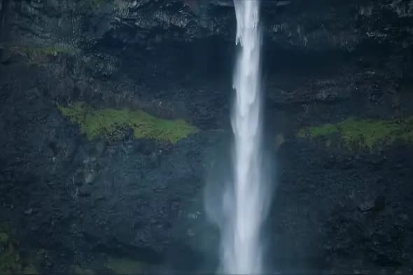 Majestic Waterfall Cascading Down Dark Rocky Cliff