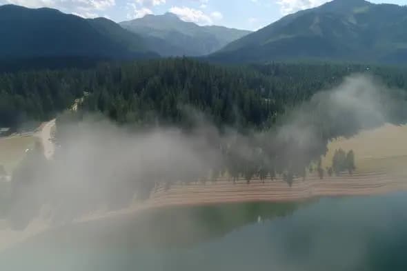 Misty Mountain Lake with Evergreen Forest and Winding Road