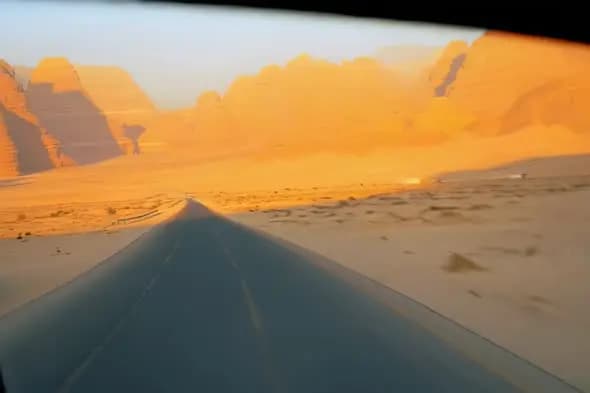 Desert Highway Through Golden Sand Dunes at Sunset