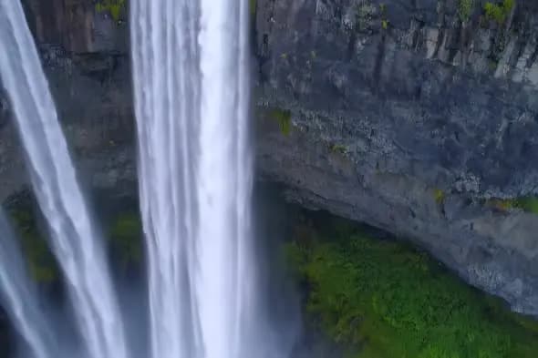 Majestic Waterfall Cascade Against Rocky Cliff Face