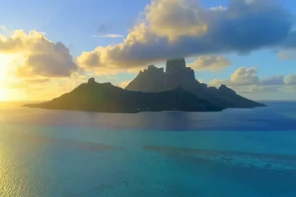 Sunset Over Tropical Island Mountain Silhouette in Turquoise Sea