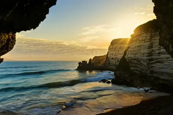 Sunset Through Coastal Cave Opening at Limestone Cliffs