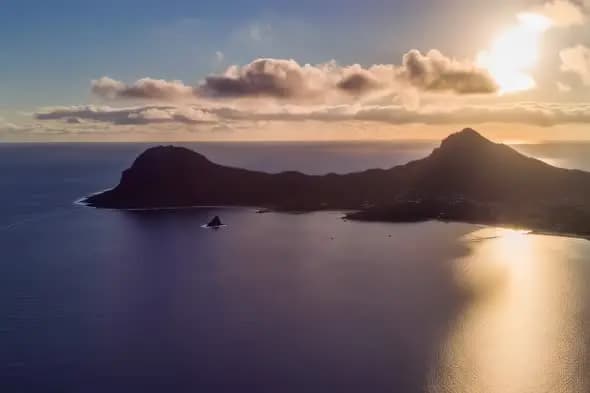 Coastal Mountain Silhouettes at Golden Sunset Over Tranquil Bay