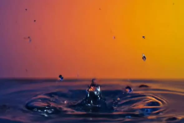 Vibrant Water Splash with Sunset Gradient Background in Slow Motion