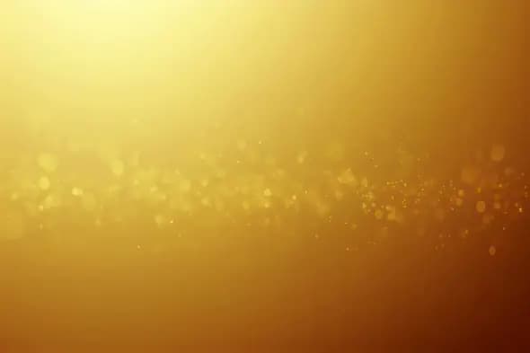 Golden particles swirling on radiant amber background