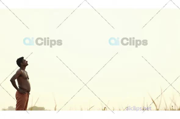 Pensive Indian Farmer Standing in the Field at Sunrise