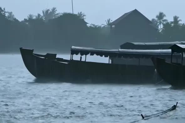 Monsoon Rains Lash Traditional Boats on Tropical River