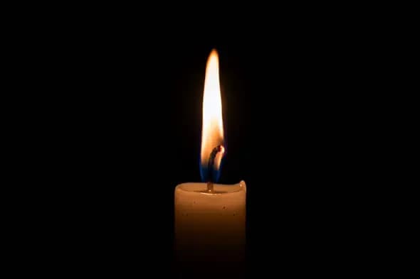 Solitary Candle Flame in Darkness