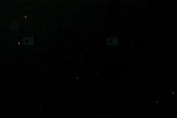 Floating Dust Particles Against Dark Background
