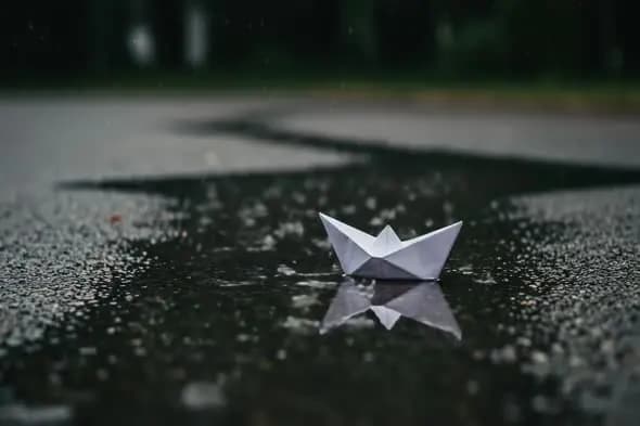 Paper Boat Floating in Rainwater