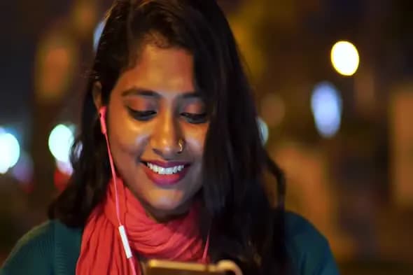 Joyful Woman Using Smartphone at Night