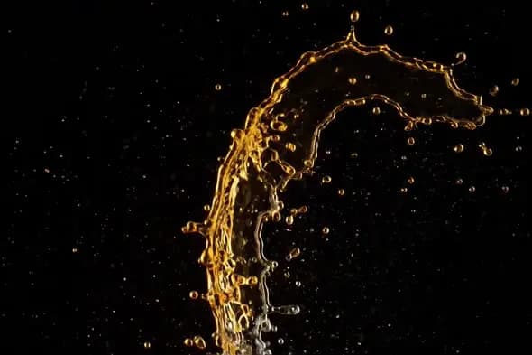 Golden Liquid Splash Arc Against Black Background