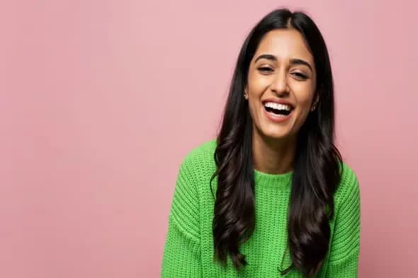 Joyful Expression in Bright Green Sweater Against Pink Background