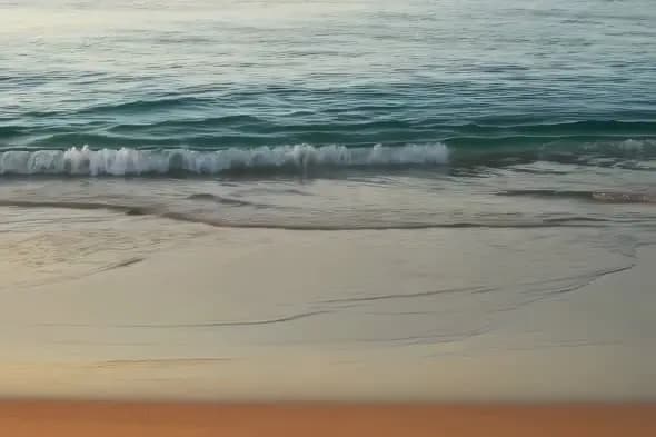 Tranquil Ocean Waves Gently Rolling onto Sandy Beach