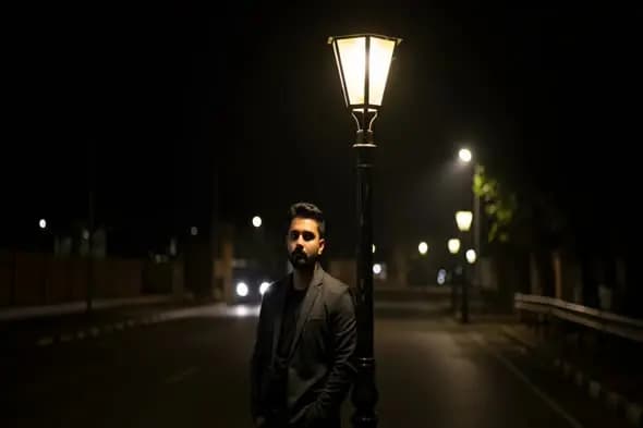 Man in a suit under street light at night