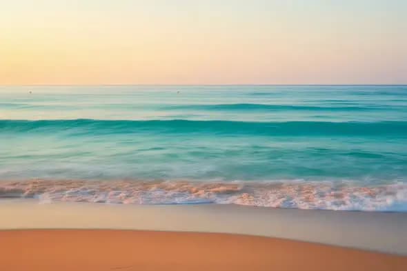 Serene Coastal Sunrise Illuminates Gentle Ocean Waves