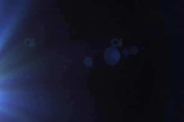 Blue Lens Flare Effect with Soft Bokeh on Dark Background