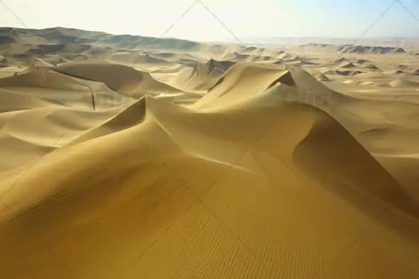 Aerial View of Vast Desert Sand Dunes Under Clear Sky