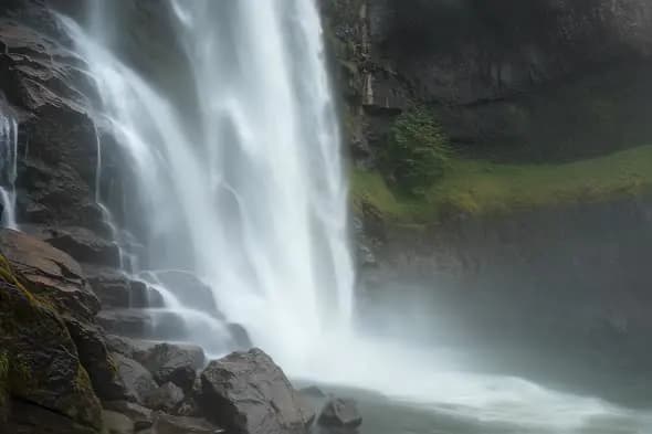 Powerful Waterfall Plunges into Misty Rocky Basin
