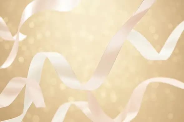 Floating White Satin Ribbons on a Soft Golden Bokeh Background