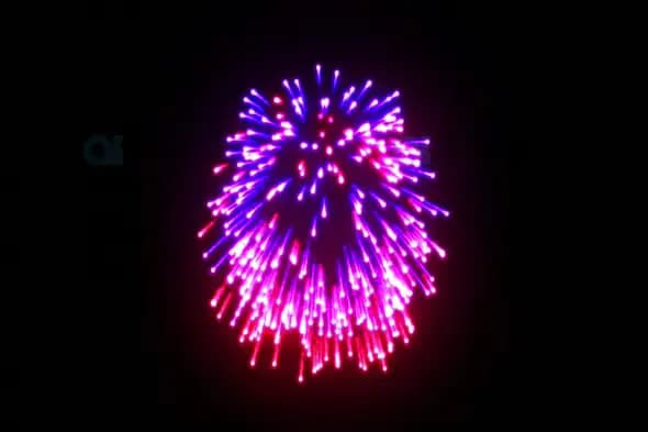 Bright Pink and Blue Fireworks Burst Against Dark Sky