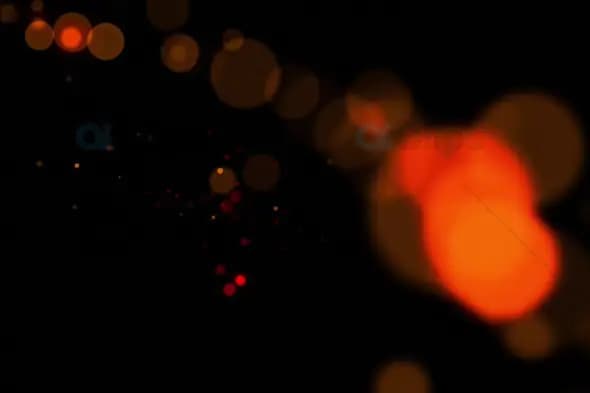 Warm Orange Bokeh Light Particles on Black Background