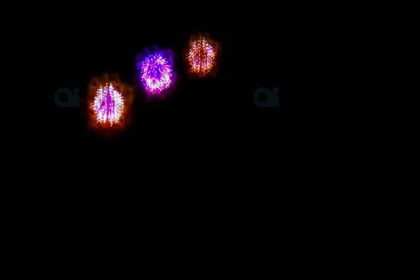 Triple Orange and Purple Fireworks Burst in Night Sky