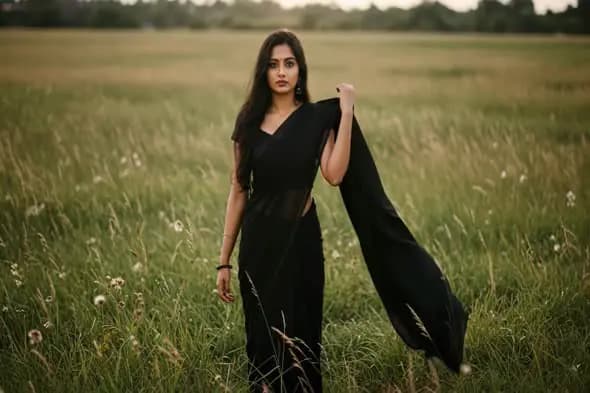 Indian woman in black saree in field