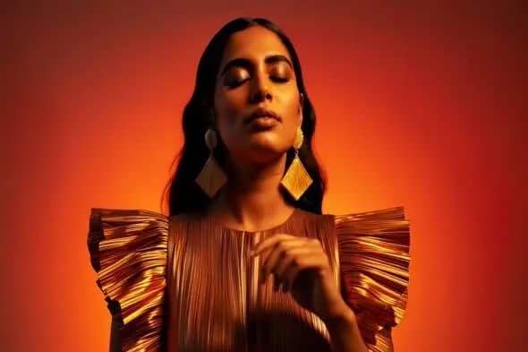Stylish Indian woman in gold dress with orange light