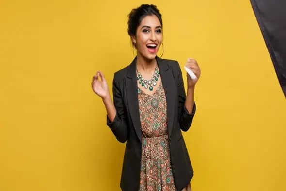 Joyful Professional Woman Celebrating Against Yellow Background