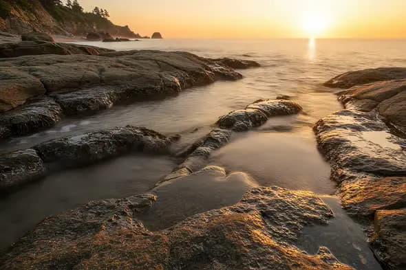 Serene Coastal Sunrise Illuminating Rocky Shore Scenery