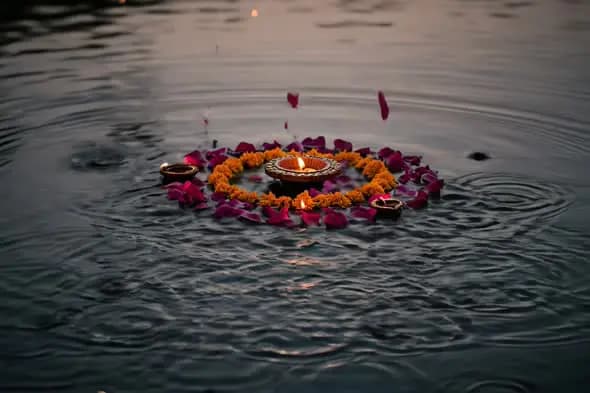 Traditional Floating Diya with Marigold and Rose Petals on Water During Festival