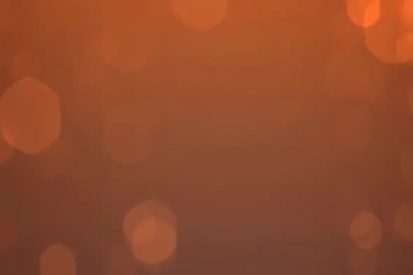 Warm amber bokeh lights on reddish brown background