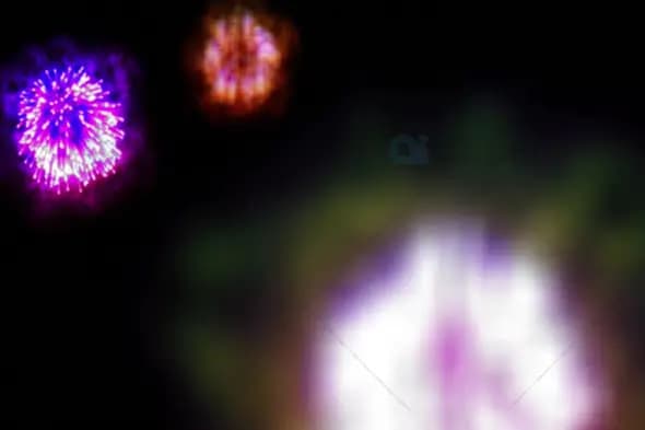 Vibrant Fireworks Burst in Purple, Orange, and White Against Night Sky