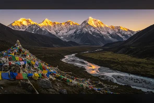 Golden Sunrise Reflections in a Himalayan Valley with Prayer Flags
