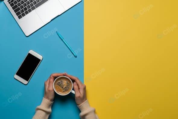 Laptop Workspace with Coffee, Smartphone, and Pen on Colorful Background