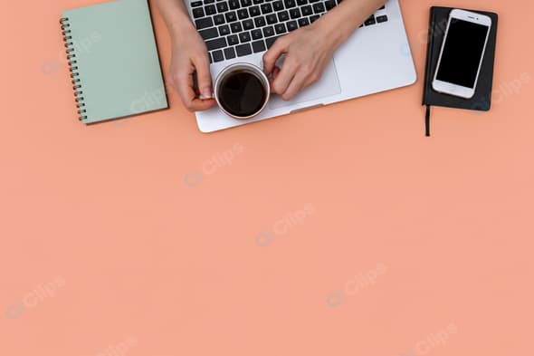 Minimal Workspace with Laptop, Coffee, and Notebooks on Peach Background