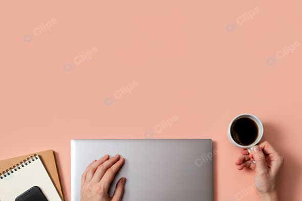 Laptop Workspace with Coffee and Notepad on Peach Background