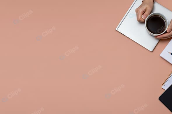 Office Desk with Coffee, Notebook, and Pencil on Peach Background