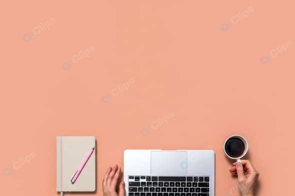 Laptop and Notebook Workspace with Coffee Cup on Peach Background