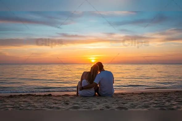 Couple Watching Vibrant Ocean Sunset on Sandy Beach